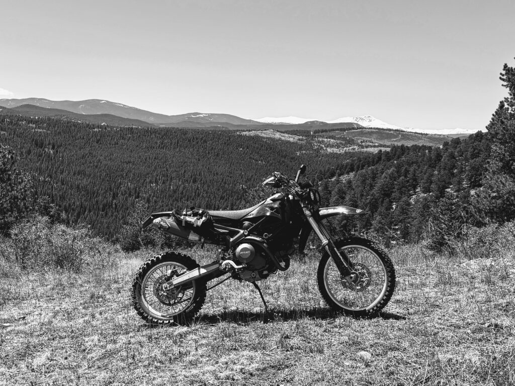 The DirtCati, a Ducati Monster 696 turned dirt bike, on a hilltop in black and white