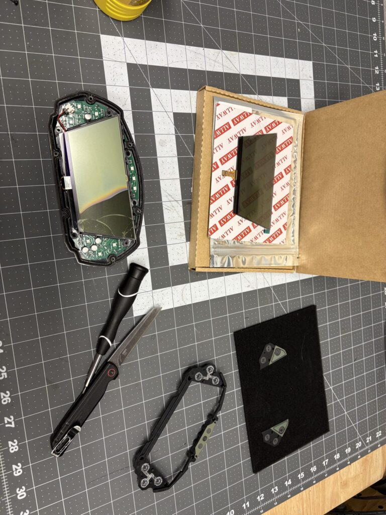 The dash display taken apart on a cutting mat