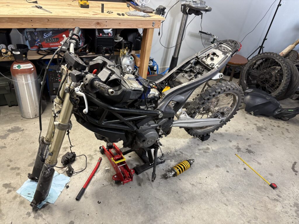 KTM 690 Enduro swingarm bolted to the Ducati with the stock yellow shock on the floor