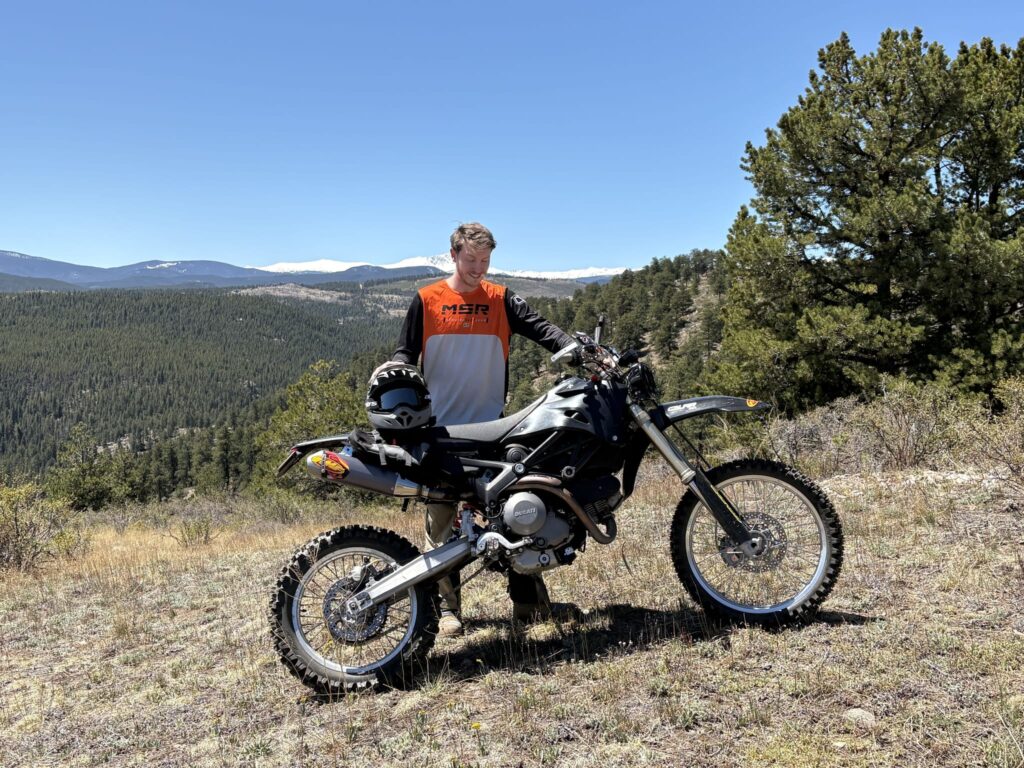 Lucas standing behind the DirtCati on a hilltop