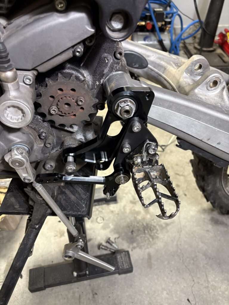 Black rearset, adapter plate, YZ450F footpeg and brake pedal on the Ducati