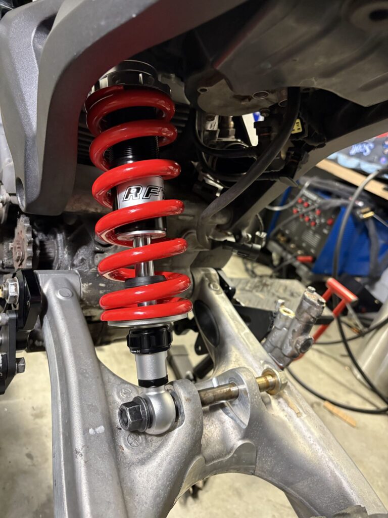 Red Honda Superhawk shock mounted on the left side of the KTM swingarm